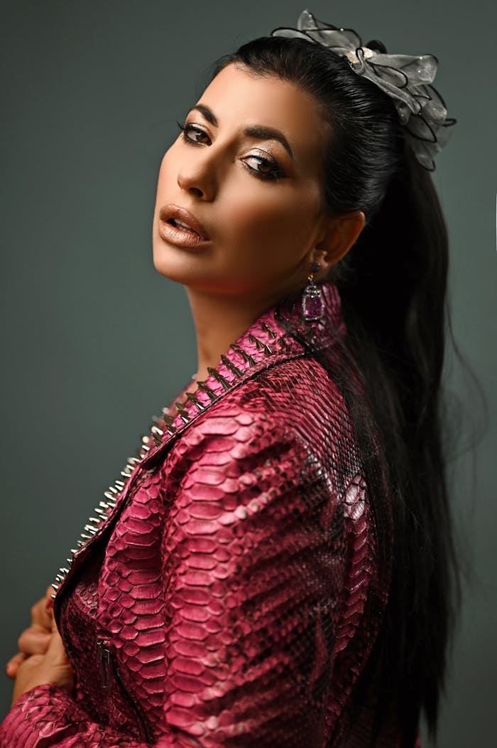 Crafting Captivating Headlines: Your awesome post title goes here Chic studio portrait of a woman in a stylish pink snakeskin jacket focusing on contemporary fashion.